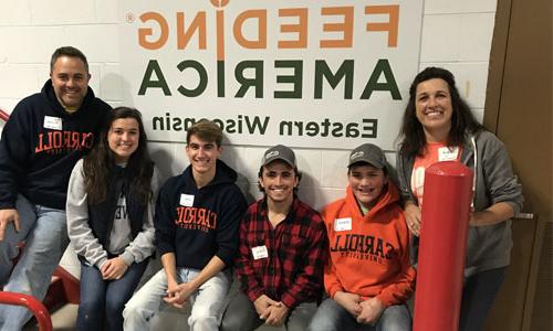 Carroll students sitting in front of Feeding America a sign.